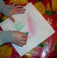 enfant en train de colorier une feuille aux pastels