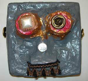 masque en papier maché peint et décoré de bouton