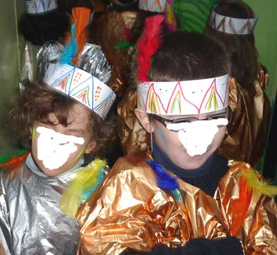 enfants portant un costume d'indien avec une couronne de plumes et une tunique en papier