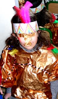 enfant portant un costume d'indien avec une couronne de plumes et une tunique en papier