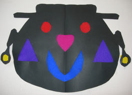 masque en papier noir avec les ouvertures bouchées en papier crépon de couleur