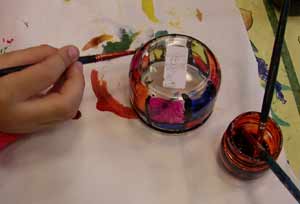 enfant en train de peindre le bougeoir de Noël à la peinture vitrail