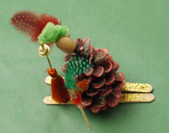 petit personnage fabriqué avec une pomme de pain, des plumes et des batonnets