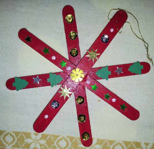 étoile de Noël faite avec des bâtons en bois peints et décorés