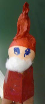 Père-Noël avec un pot peint en rouge, une boule de cotillon et un chapeau en papier