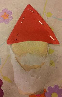 tête de Père-Noël avec un chapeau en carton rouge agrafé